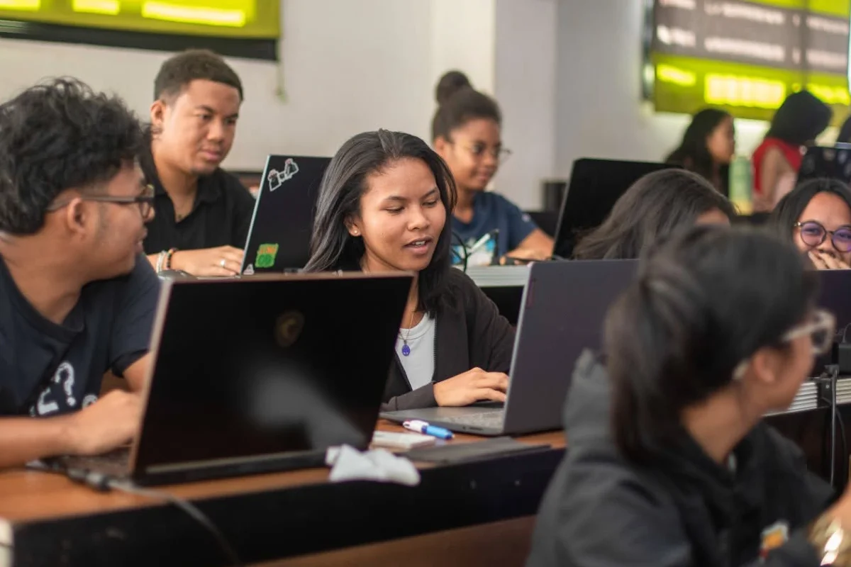 Étudiants d’IT University en projet devant leurs ordinateurs portables en salle machines.